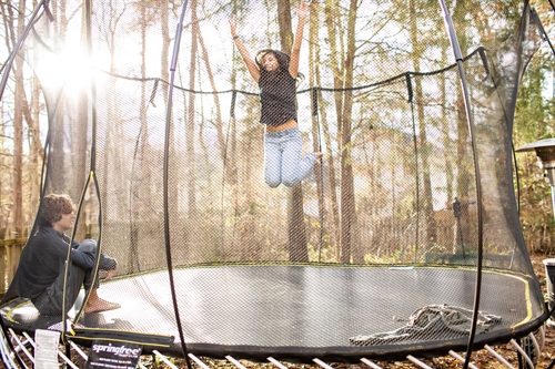 Two people enjoying a trampoline towards the end of summer.