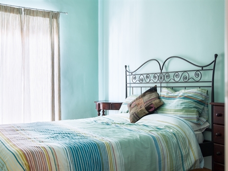 A bed made up with bedding, duvet and pillow.