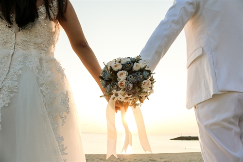 A bridal couple holding hands.