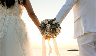 A bridal couple holding hands.