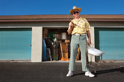 A man at his storage unit holding a chair