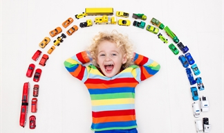 A child surrounded by small brightly coloured toys